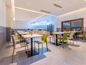 un restaurant avec des tables et des chaises dans une salle dans l'établissement Borrman Hotel Chongqing Bishan Central Street, à Daxing