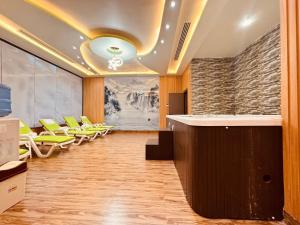 Un vestíbulo con sillas amarillas y un gran cuadro. en Glory Regency Hotel, en Yuba