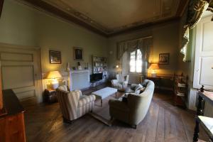 a living room with two chairs and a fireplace at Palazzo Guicciardi in San Bernardo