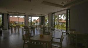 une salle à manger avec tables, chaises et fenêtres dans l'établissement Laprima Hotel, à Labuan Bajo