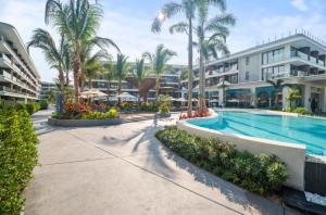 a pool at a resort with palm trees and buildings at Sunshine Layan Beach Resort 2 bedroom #84192 in Layan Beach +25 photos