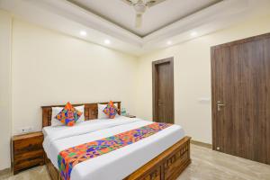 a bedroom with a large bed and a wooden door at Hotel Supreme in Gurgaon +15 photos