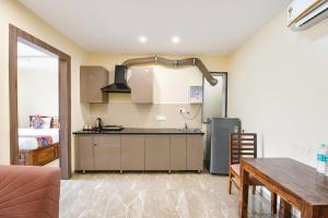 a kitchen with a refrigerator and a table in a room at Hotel Supreme in Gurgaon