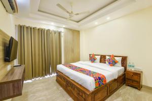 a bedroom with a bed and a flat screen tv at Hotel Supreme in Gurgaon