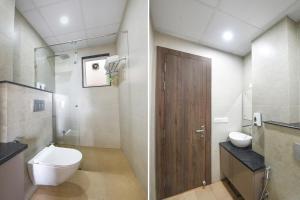 a bathroom with a toilet and a wooden door at Hotel Supreme in Gurgaon