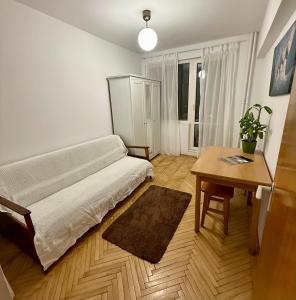 ein Wohnzimmer mit einem Bett und einem Tisch in der Unterkunft Victoriei Residence in Braşov