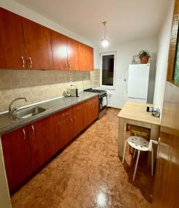 eine Küche mit Holzschränken und einem weißen Kühlschrank in der Unterkunft Victoriei Residence in Braşov