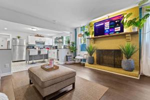 a living room with a large tv and a living room with a couch at *Super close to Hospitals|UAB|Open fl plan|2 bdr in Birmingham +22 photos