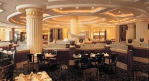 a restaurant with tables and chairs in a room with columns at Sanya Baohong Hotel in Sanya
