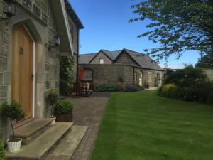 a house with a patio and a yard with green grass at Hazel Manor in Harrogate