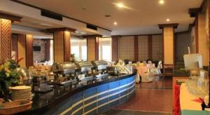 un restaurant avec une ligne de buffet avec des tables dans l'établissement Thepnakorn Hotel, à Ban Khok Wat