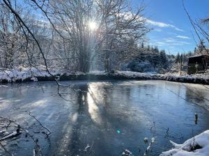 un río en la nieve con el sol brillando en Fuchs & Has`, en Marienberg