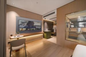 a living room with a tv on a wall at Jiting International Hotel Jiaotong University Light Rail Station in Chongqing