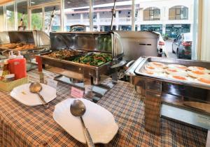 a buffet line with plates of food and spoons at G2 Hotel Group in Ban Kohong
