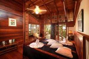 - une chambre avec un lit et des oreillers dans l'établissement Aguila de Osa Rainforest Lodge, à Drake