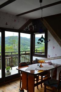 comedor con mesa y algunas ventanas en Villa AdiArt, en Arda