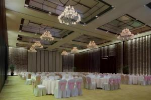a banquet hall with white tables and chairs and chandeliers at Eadry Royal Garden Hotel Haikou in Haikou +276 photos