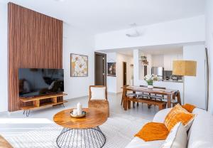 Gorgeous 1 Bed Apartment in Blue Bay Walk في الشارقة: غرفة معيشة مع أريكة وطاولة