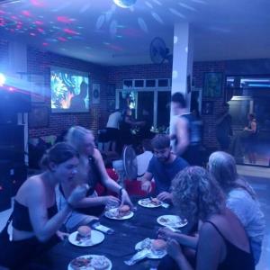 a group of people sitting around a table eating food at Rose's Roadhouse in Pai