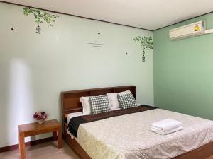 a bedroom with a bed and aokedokedokedoked at บ้านไม้พิชา หล่มเก่า in Lom Kao