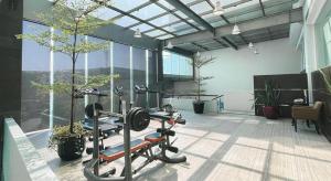 a fitness room with a gym with trees and plants at Grage Hotel Cirebon in Cirebon