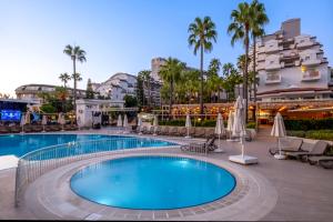a pool at a hotel with chairs and umbrellas at Iz Flower Side Beach Hotel in Side