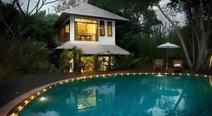 une grande piscine devant une maison dans l'établissement Rajapruek Place, à Chiang Mai