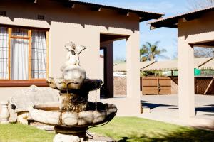 a fountain in front of a house at Welgerust Bed & Breakfast in Piet Retief