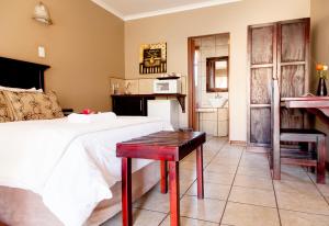 a bedroom with a bed and a table in it at Welgerust Bed & Breakfast in Piet Retief