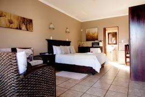 a bedroom with a large bed and a couch and a chair at Welgerust Bed & Breakfast in Piet Retief