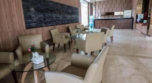 ein Esszimmer mit Tischen und Stühlen und einer Tafel in der Unterkunft Hotel 61 Medan in Medan