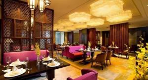 a restaurant with tables and chairs and purple furniture at New Century Grand Hotel Hangzhou Zheshang in Yuhang