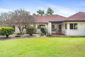 una casa con césped delante en Peaceful Family Home: 4-Bed Pool Alfresco Dining, en Albany Creek