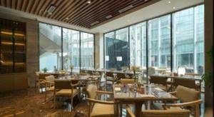 un restaurant avec des tables, des chaises et des fenêtres dans l'établissement Beijing Grand Skylight International Hotel, à Pékin