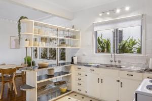 eine weiße Küche mit weißen Schränken und einem Tisch in der Unterkunft Beachside 3-Bed family Home with Parking & Veranda in Scarborough