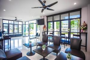 ein Salon mit Stühlen und Tischen und einem Deckenventilator in der Unterkunft The Bed Hotel Phitsanulok in Sathani Phitsanulok