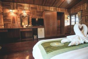 une chambre avec un lit avec des serviettes blanches dessus dans l'établissement Baan Baitan Resort, à Ban Tha Fat