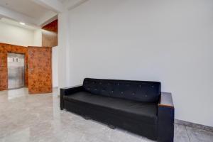 un sofá de cuero negro en una habitación con puerta en Collection O Kanifnath Trek Pune, en Jadhavwadi