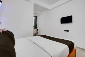 Un dormitorio con una cama con un televisor en la pared. en Collection O Kanifnath Trek Pune, en Jadhavwadi 28 fotos más