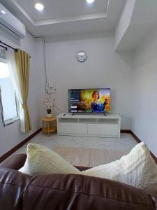 a living room with a couch and a flat screen tv at Remas Homestay Hat Yai in Sathani Khlong Rian