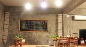 un menu sur le mur d'un restaurant avec une table dans l'établissement Peisanae Faikeng Resort, à Ban Na Kham