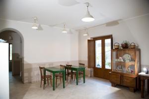 a dining room with a green table and chairs at Il Moro Bianco in Teano