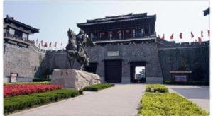 a building with a statue in front of it at Suqian Hengli International Hotel in Suqian