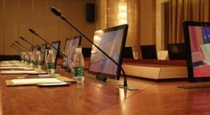 a long table with a row of computers and microphones at Suqian Hengli International Hotel in Suqian +125 photos