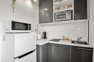 une cuisine avec un réfrigérateur blanc et un évier dans l'établissement Charming 1-Bed with Fireplace by the Beach, à Melbourne