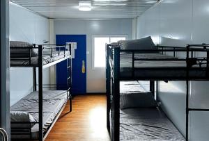 a room with three bunk beds and a window at RedDoorz at Tandikan Suites El Nido in El Nido