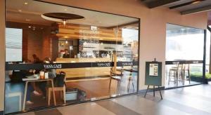 ein Restaurant mit einem großen Glasfenster in einem Gebäude in der Unterkunft Leevana Hotel in Sathani Hat Yai