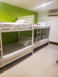 2 literas en una habitación con una pared verde en Lucky Dorm, en Islas Phi Phi