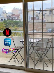 a chair and a table on a balcony at Larnaca Comfort Rooms With Smart TV & Netflix in Larnaca +15 photos