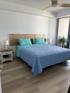 a bedroom with a large bed with blue sheets at Bluewater Haven in Buddina